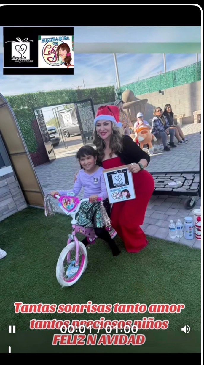 A volunteer hands a wrapped box of toys to a young girl